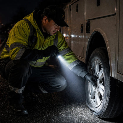 Cree Lighting X14 tactical LED flashlight illuminating roadside flat tire repair at night