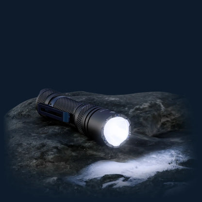 Cree Lighting X16 tactical flashlight illuminated on wet rock at night with beam on